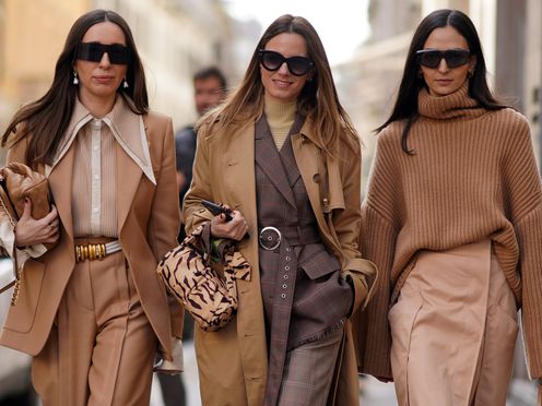 Showing what colors go with tan, three women wear tan, brown, and beige outfits at Fall 2023 fashion week.